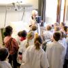 Een vrijwilligster legt uit aan de schoolkinderen welke onderzoeken er plaatsvinden bij een opname.