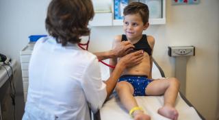Kinderarts onderzoekt jonge patiënt met stethoscoop